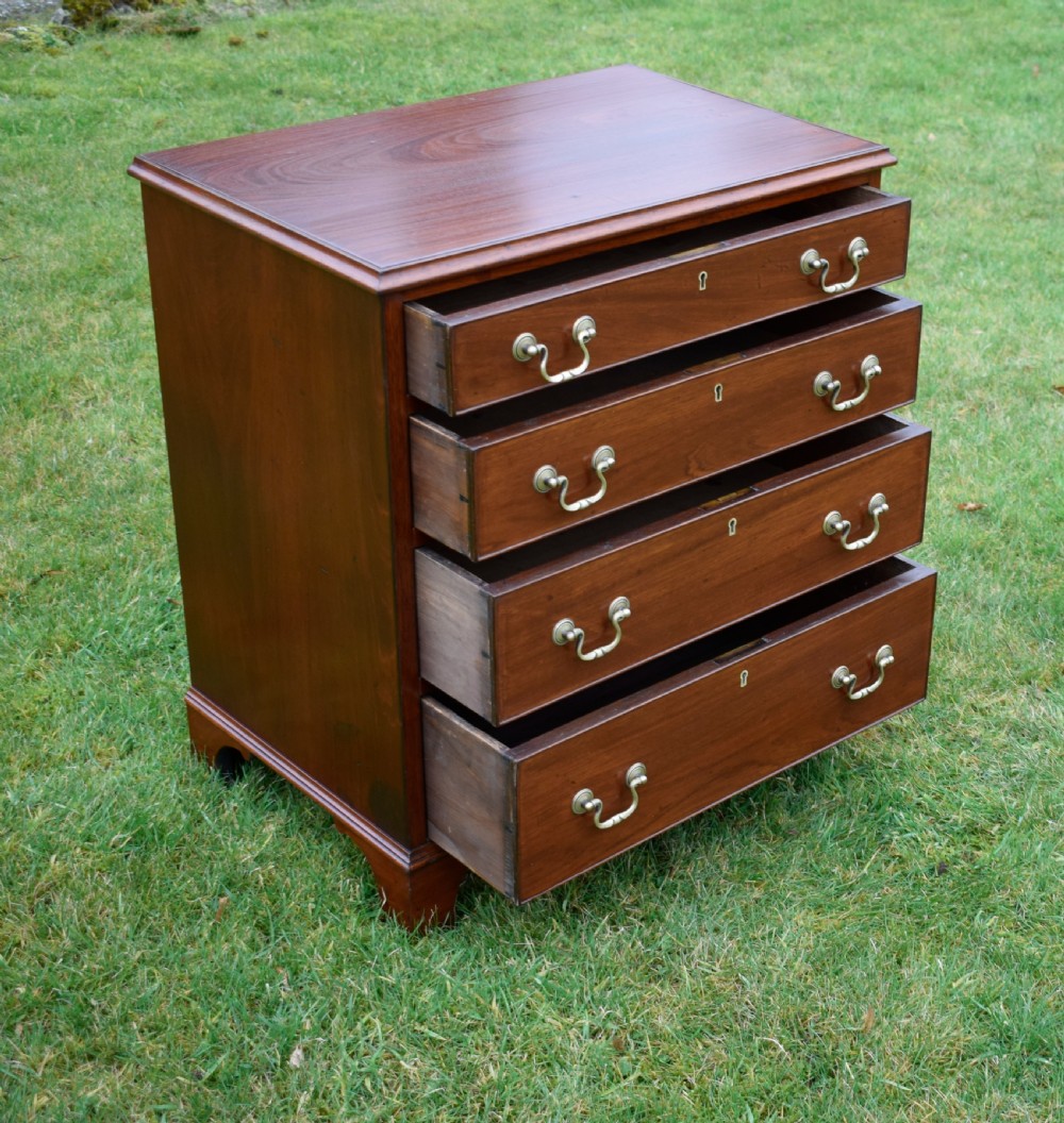 A mahogany chest of drawers featuring four graduated drawers with brass swan-neck handles and bracket feet. View VIII