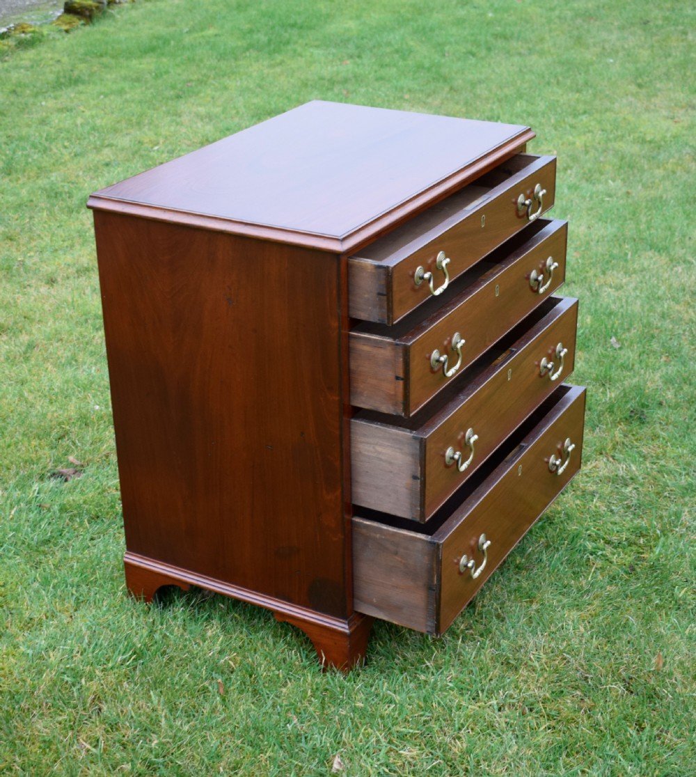 A mahogany chest of drawers featuring four graduated drawers with brass swan-neck handles and bracket feet. View X
