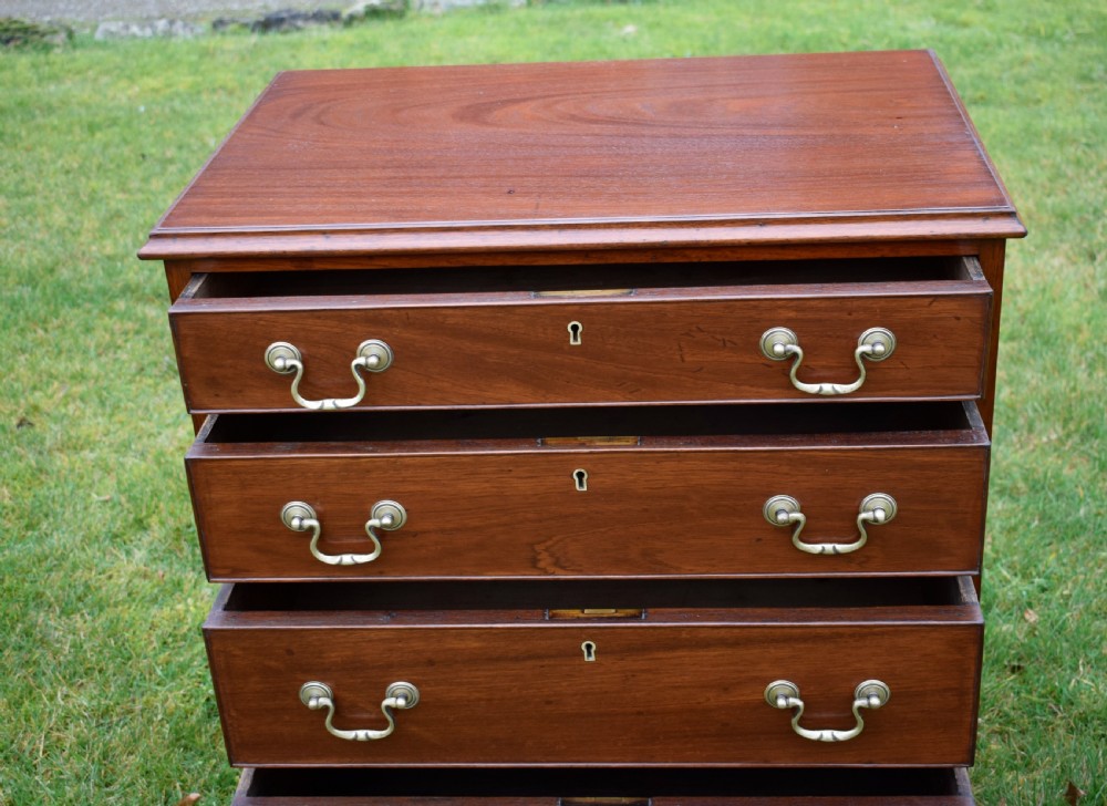 A mahogany chest of drawers featuring four graduated drawers with brass swan-neck handles and bracket feet. View XII