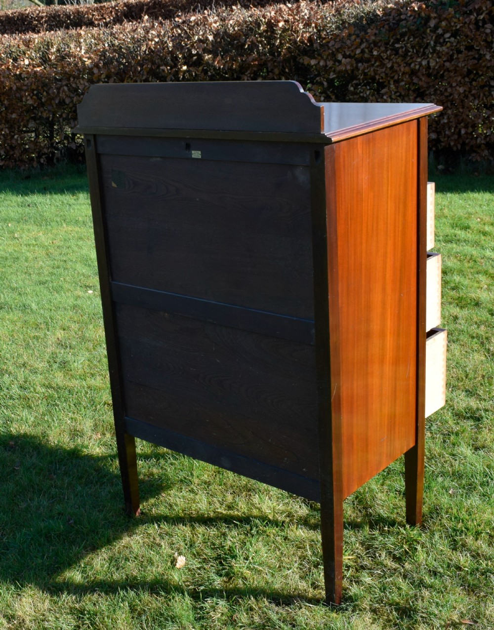 An Edwardian mahogany tall chest of drawers featuring fine string inlay, brass ring handles, five drawers, a low raised backboard, and square tapered legs. View XIV