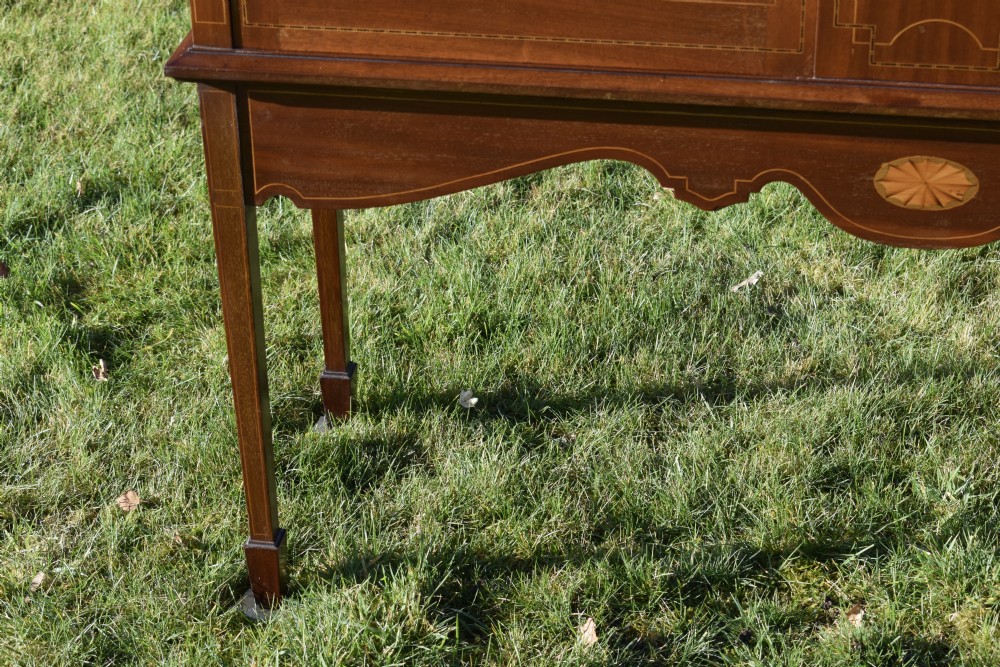 An early 20th-century mahogany Art Nouveau display cabinet featuring glazed doors, central inlaid botanical marquetry, and a fabric-lined interior on slender legs. View XI