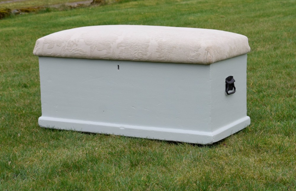 A Victorian painted pine blanket box featuring a cream upholstered cushioned top and iron drop side handles. View II