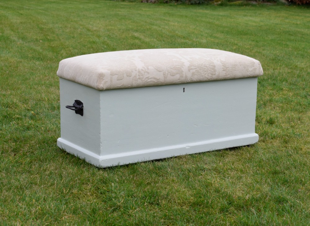 A Victorian painted pine blanket box featuring a cream upholstered cushioned top and iron drop side handles. View IV