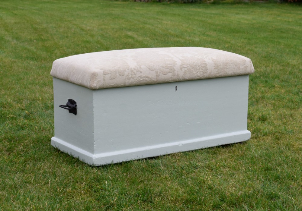 A Victorian painted pine blanket box featuring a cream upholstered cushioned top and iron drop side handles. View V