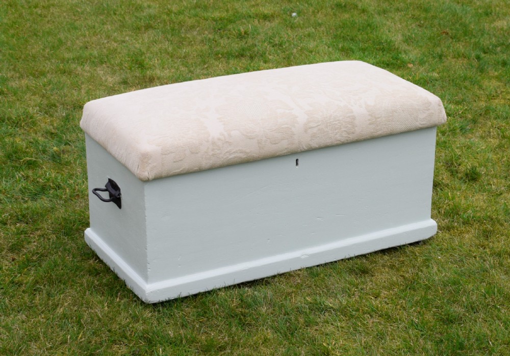 A Victorian painted pine blanket box featuring a cream upholstered cushioned top and iron drop side handles. View VII