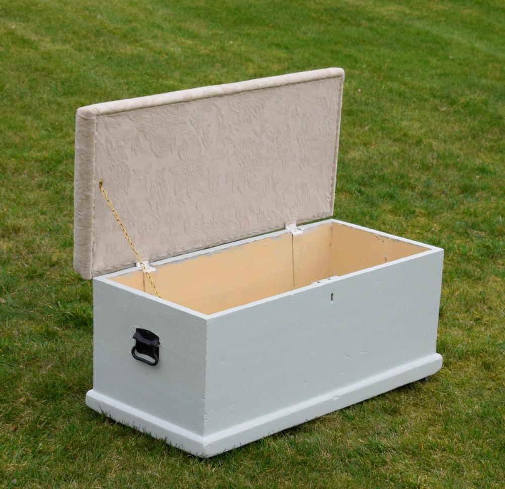 A Victorian painted pine blanket box featuring a cream upholstered cushioned top and iron drop side handles. View VIII