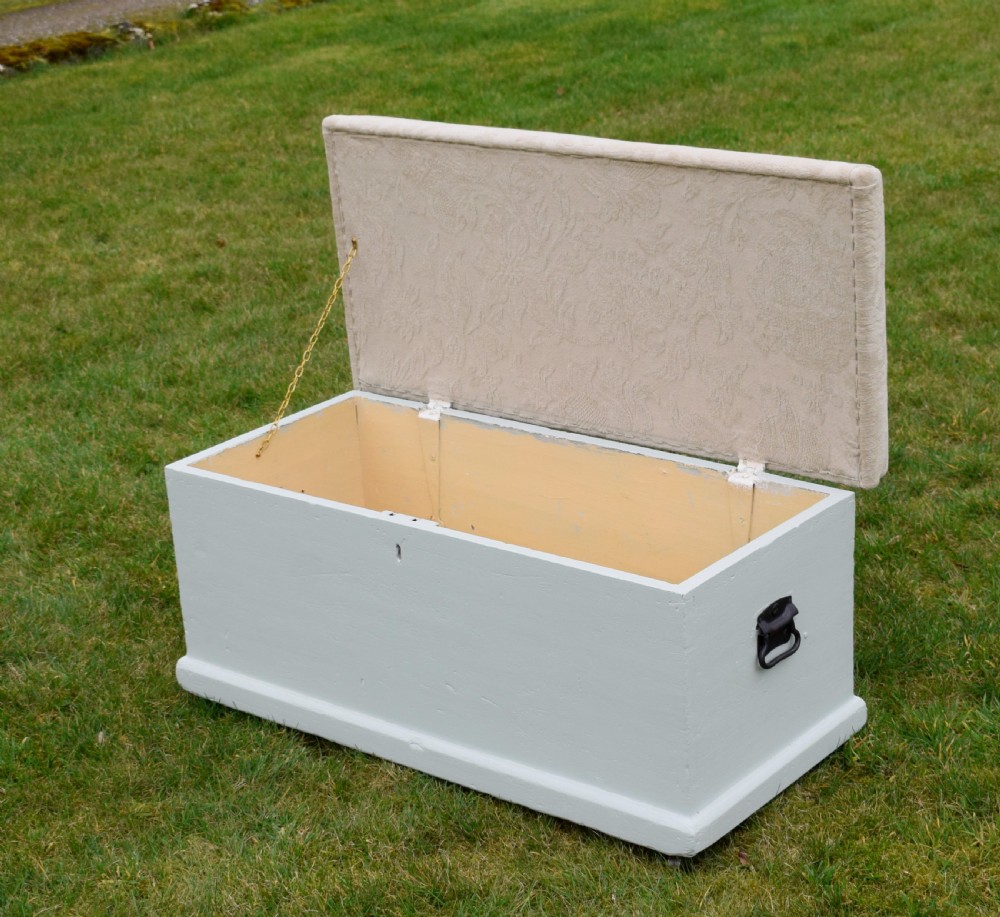 A Victorian painted pine blanket box featuring a cream upholstered cushioned top and iron drop side handles. View IX