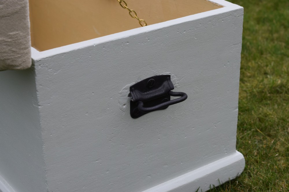 A Victorian painted pine blanket box featuring a cream upholstered cushioned top and iron drop side handles. View XIII