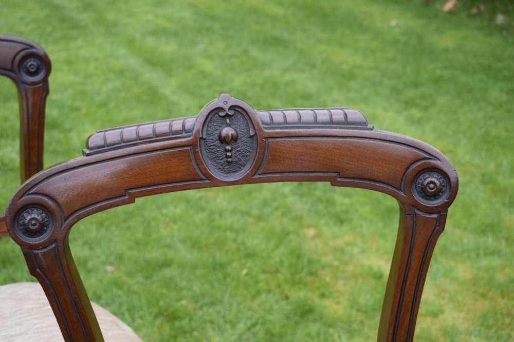 Set of four Victorian walnut dining chairs with carved open backs, turned front legs, and beige fabric upholstered seats. View VII