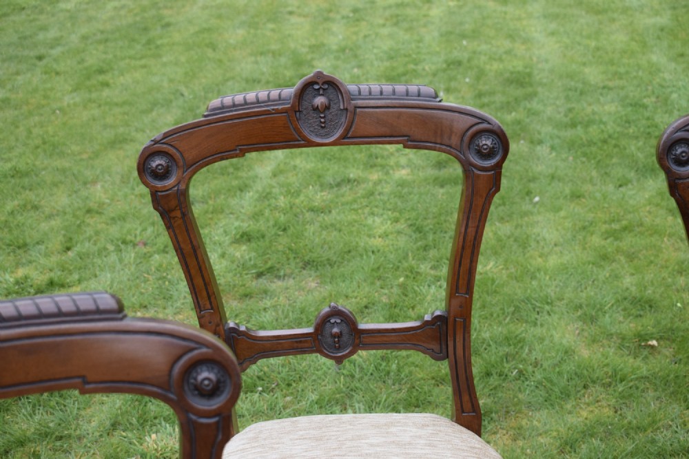 Set of four Victorian walnut dining chairs with carved open backs, turned front legs, and beige fabric upholstered seats. View VIII