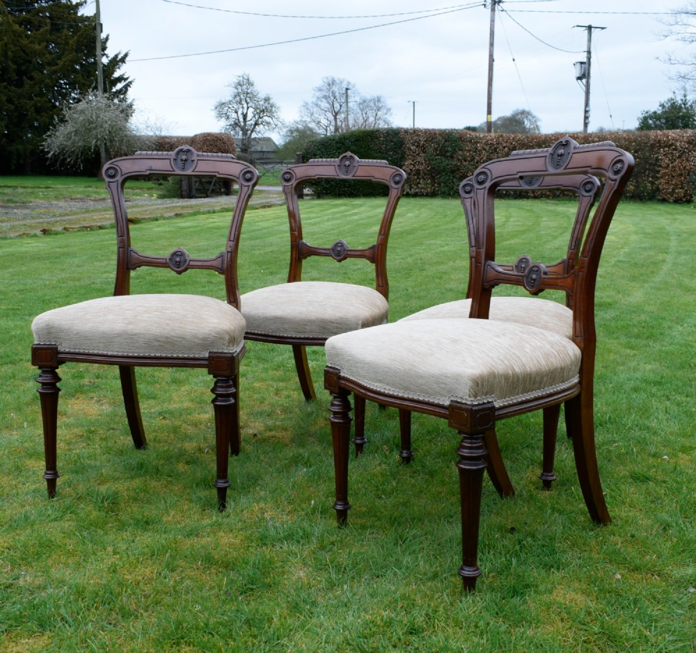 Set of four Victorian walnut dining chairs with carved open backs, turned front legs, and beige fabric upholstered seats. View XI