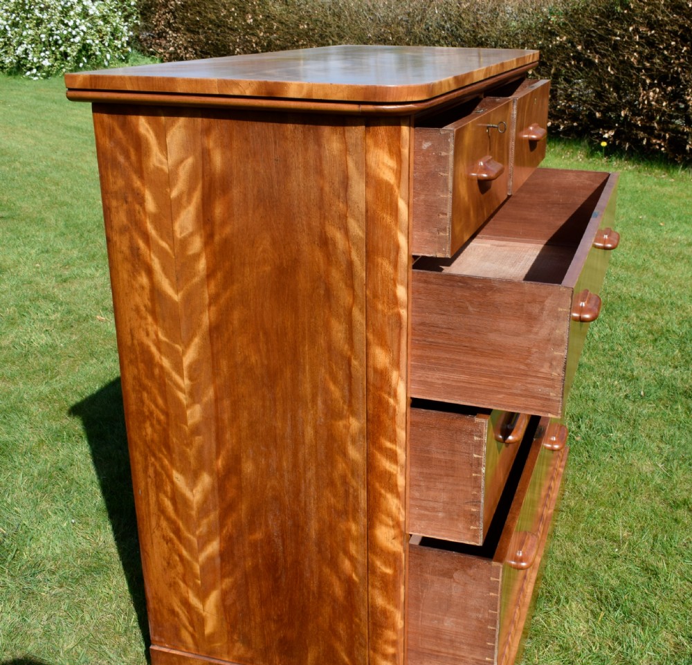 Victorian golden birch chest of drawers featuring a two-over-three drawer configuration, rounded corners, integrated timber handles, and a plinth base. View XVIII
