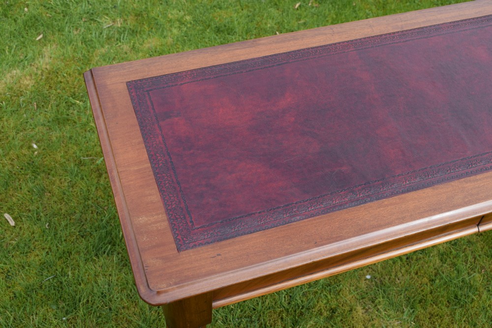 A rectangular Victorian mahogany writing desk featuring a burgundy leather inset top, two frieze drawers, and four turned wooden legs. View VIII