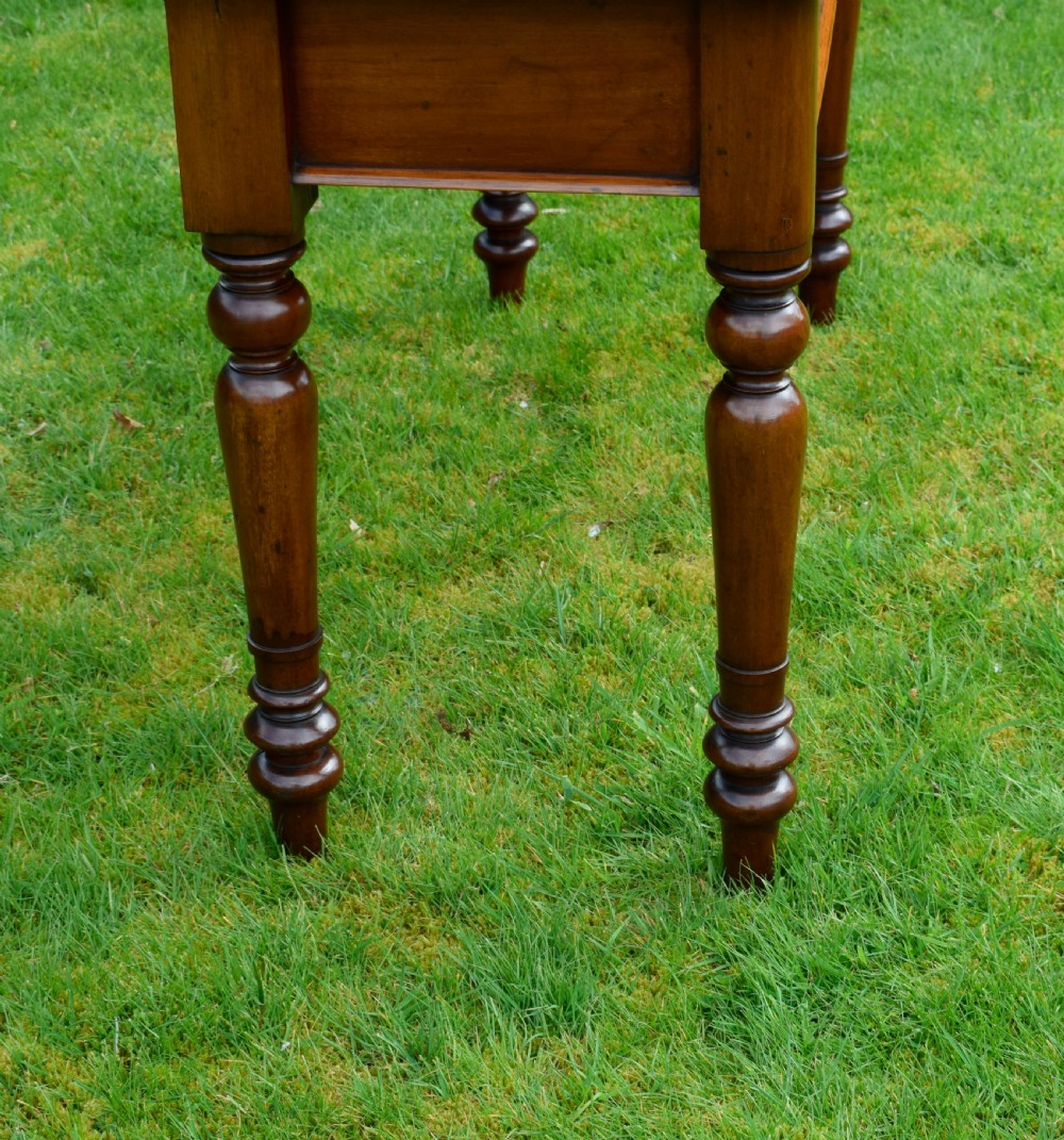 A rectangular Victorian mahogany writing desk featuring a burgundy leather inset top, two frieze drawers, and four turned wooden legs. View XIII