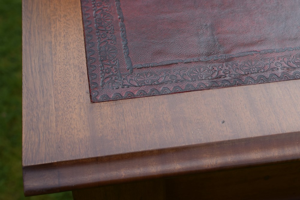 A rectangular Victorian mahogany writing desk featuring a burgundy leather inset top, two frieze drawers, and four turned wooden legs. View XVI