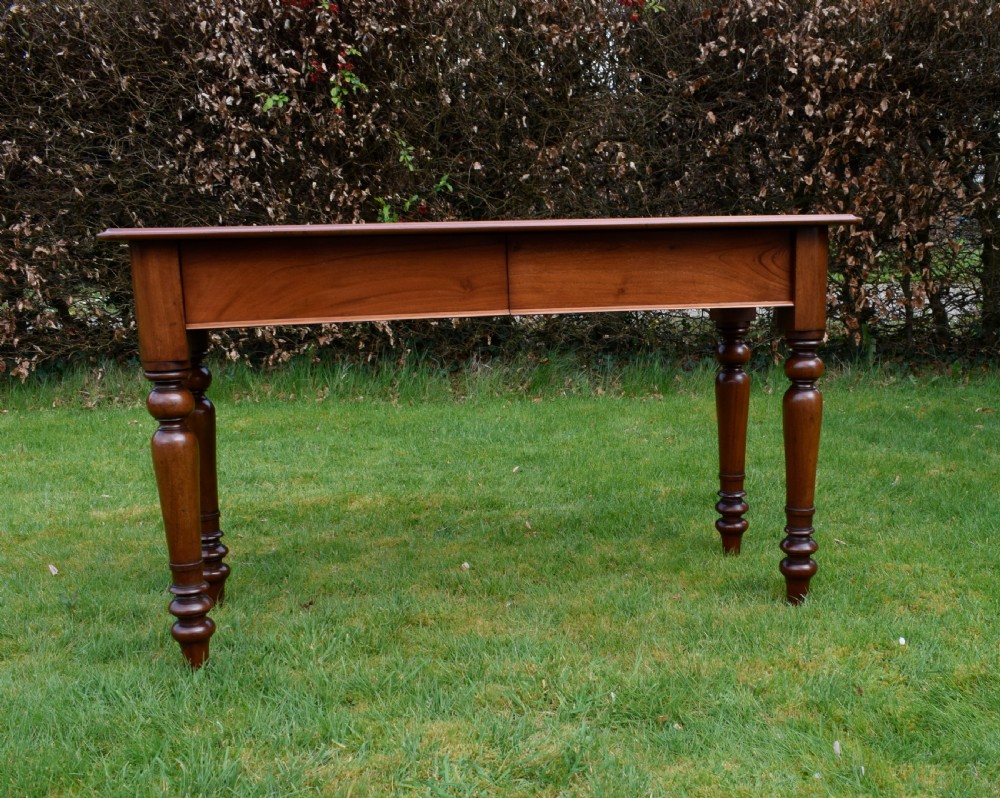 A rectangular Victorian mahogany writing desk featuring a burgundy leather inset top, two frieze drawers, and four turned wooden legs. View XVIII