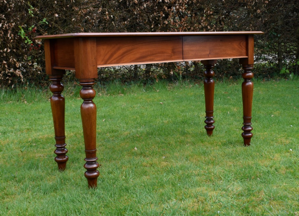 A rectangular Victorian mahogany writing desk featuring a burgundy leather inset top, two frieze drawers, and four turned wooden legs. View XXI
