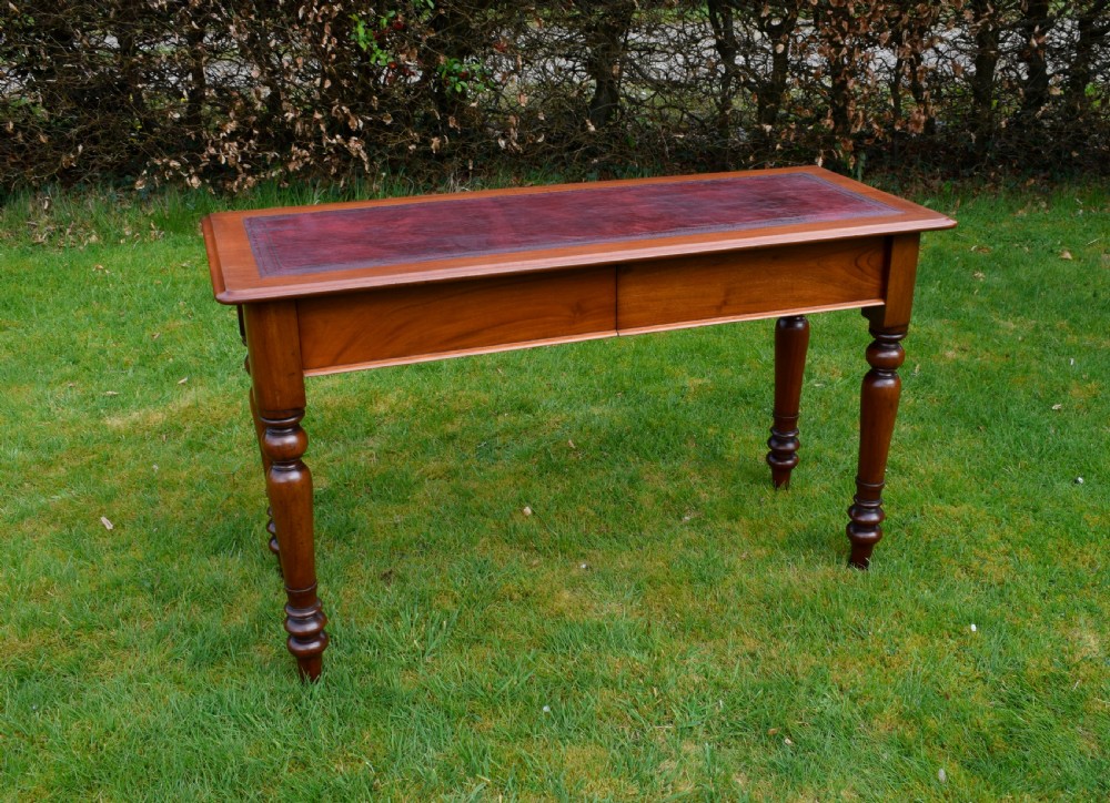 A rectangular Victorian mahogany writing desk featuring a burgundy leather inset top, two frieze drawers, and four turned wooden legs. View XXII