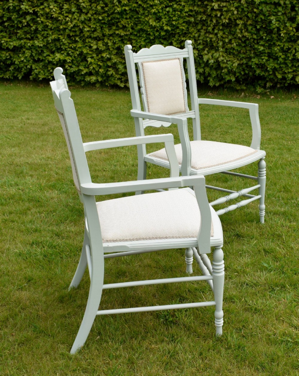 A pair of painted pale green Edwardian open armchairs featuring cream upholstered seats, padded backrest panels, turned front legs, and scalloped top rails. View IV
