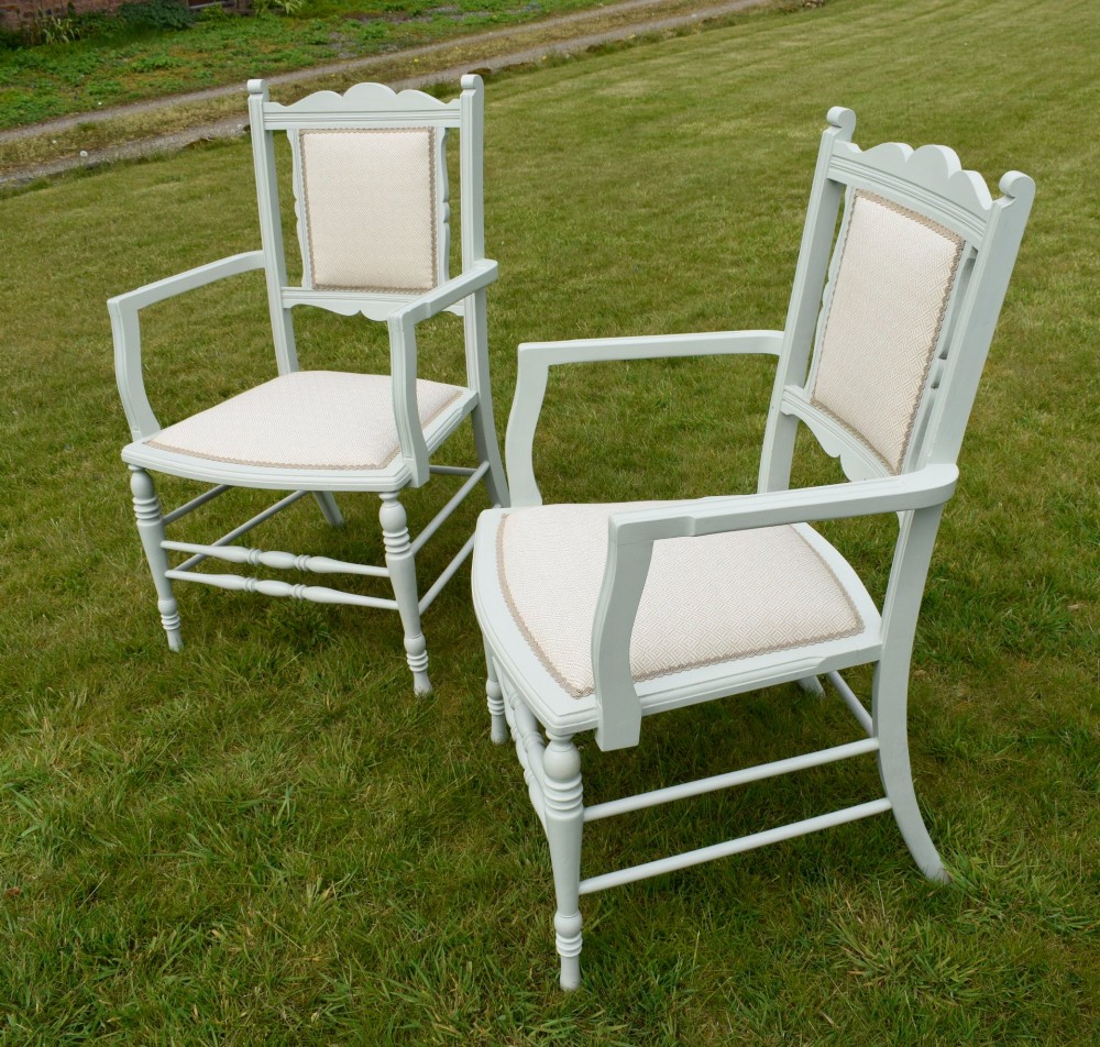 A pair of painted pale green Edwardian open armchairs featuring cream upholstered seats, padded backrest panels, turned front legs, and scalloped top rails. View IX