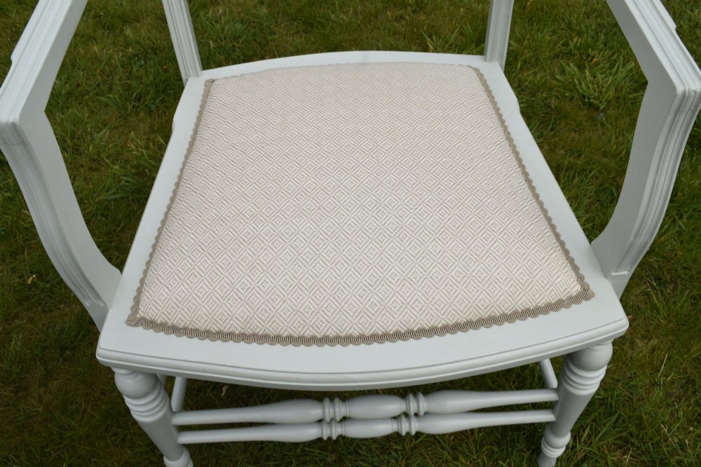 A pair of painted pale green Edwardian open armchairs featuring cream upholstered seats, padded backrest panels, turned front legs, and scalloped top rails. View XI