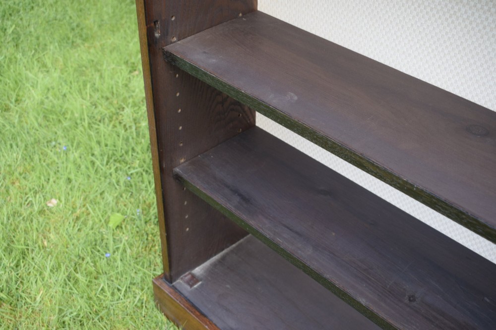 A dark oak glazed cabinet featuring a single glass door opening to internal shelving backed with a neutral patterned fabric lining. View XII