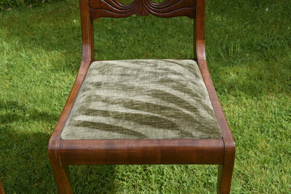 A pair of mahogany side chairs with curved tablet top rails, carved back splats, and green patterned upholstered seats. View V