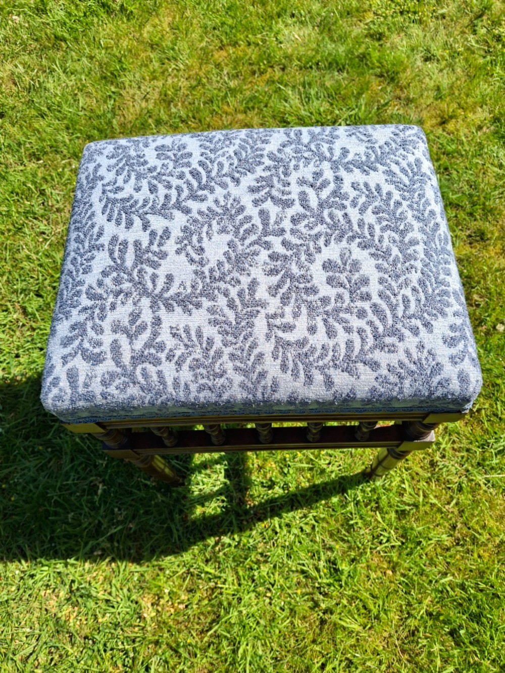 An Edwardian dark wood piano stool with turned spindles and a patterned blue fabric upholstered seat. View VII