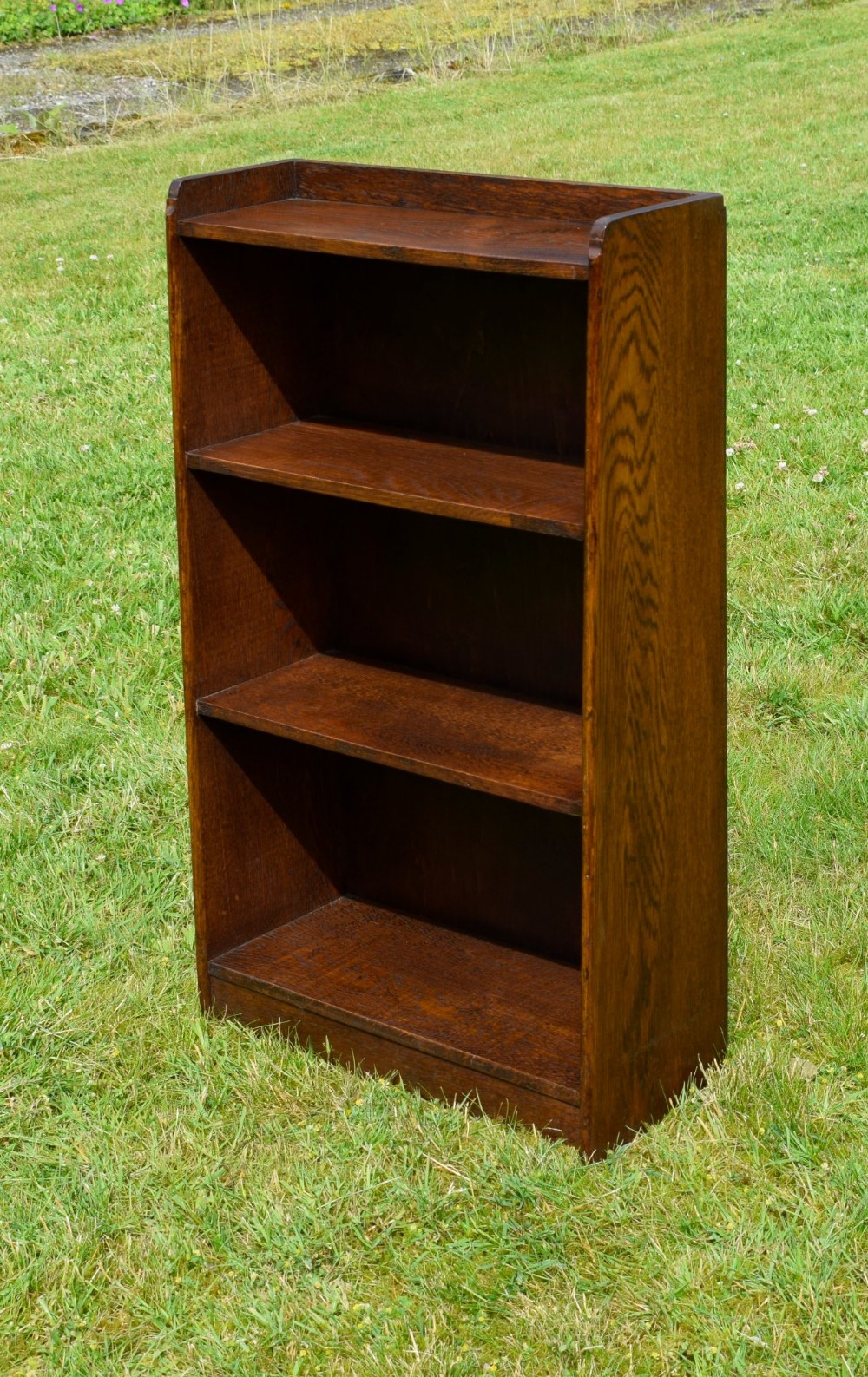 An early 20th-century open oak bookcase featuring four fixed shelves, solid side panels, and a low gallery back top. View III