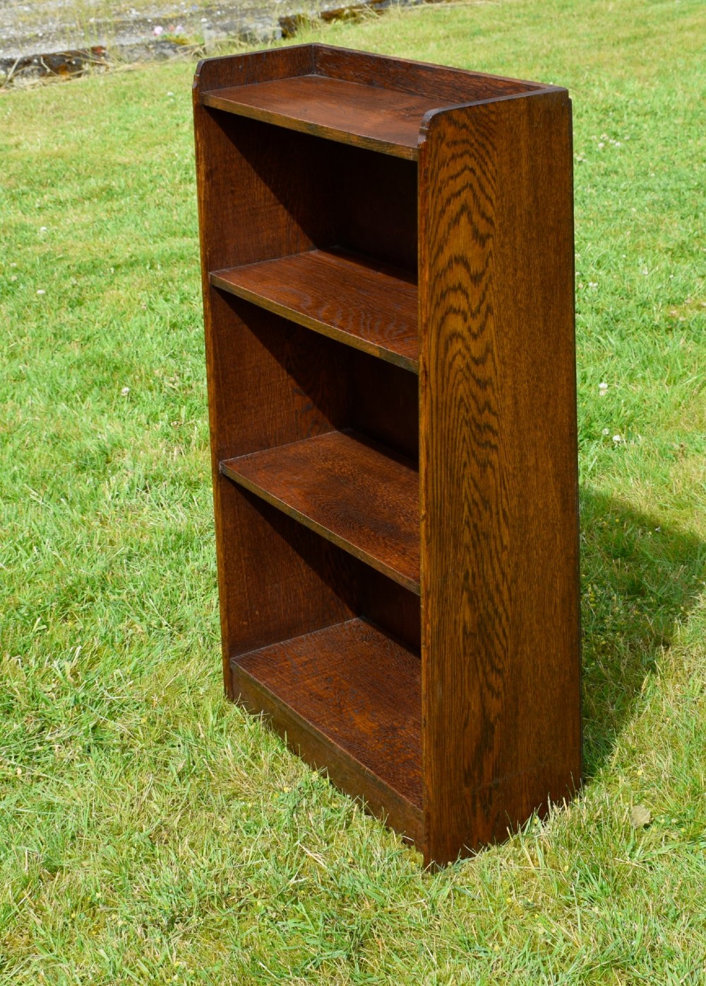 An early 20th-century open oak bookcase featuring four fixed shelves, solid side panels, and a low gallery back top. View XIII