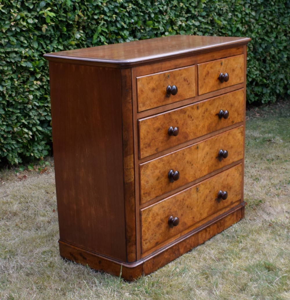 A Victorian burr walnut chest of drawers featuring two short over three long graduated drawers with turned wooden knobs and a solid plinth base. View VIII
