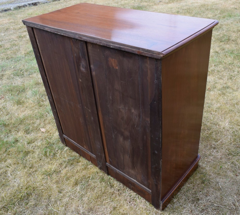 A Victorian burr walnut chest of drawers featuring two short over three long graduated drawers with turned wooden knobs and a solid plinth base. View XII