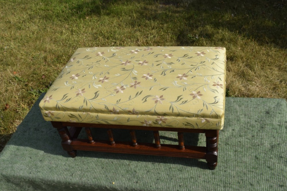 A low rectangular mahogany footstool featuring turned wood spindles and a yellow floral pattern padded fabric top. View III