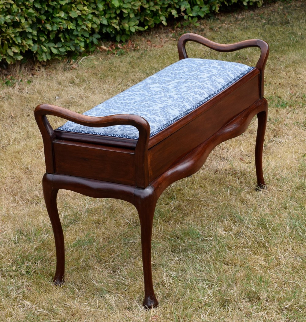 A mahogany duet piano stool with a blue patterned upholstered seat and carved cabriole legs. View II