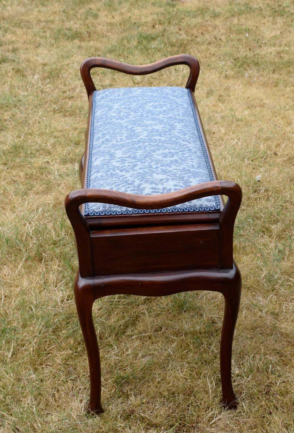 A mahogany duet piano stool with a blue patterned upholstered seat and carved cabriole legs. View VI