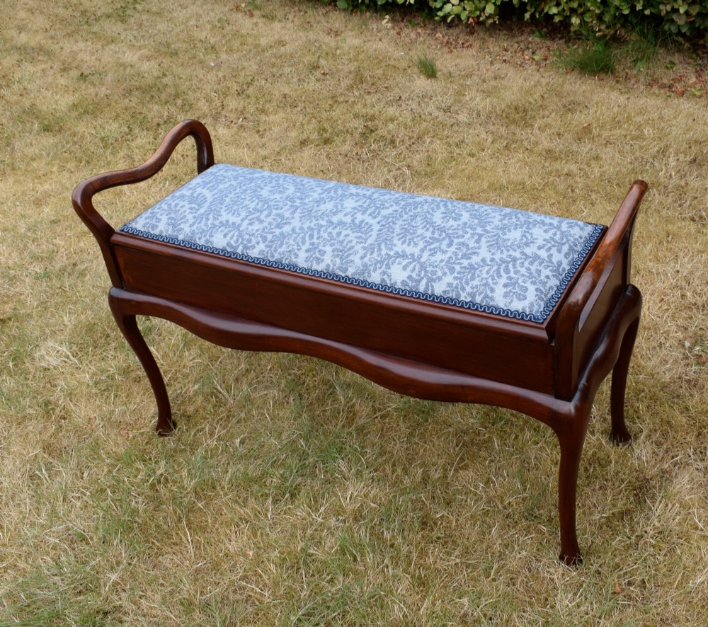 A mahogany duet piano stool with a blue patterned upholstered seat and carved cabriole legs. View VII