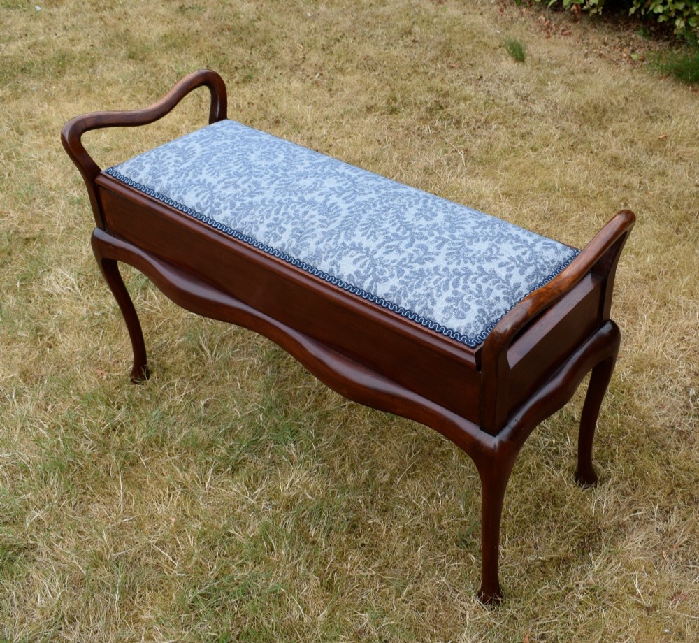 A mahogany duet piano stool with a blue patterned upholstered seat and carved cabriole legs. View IX