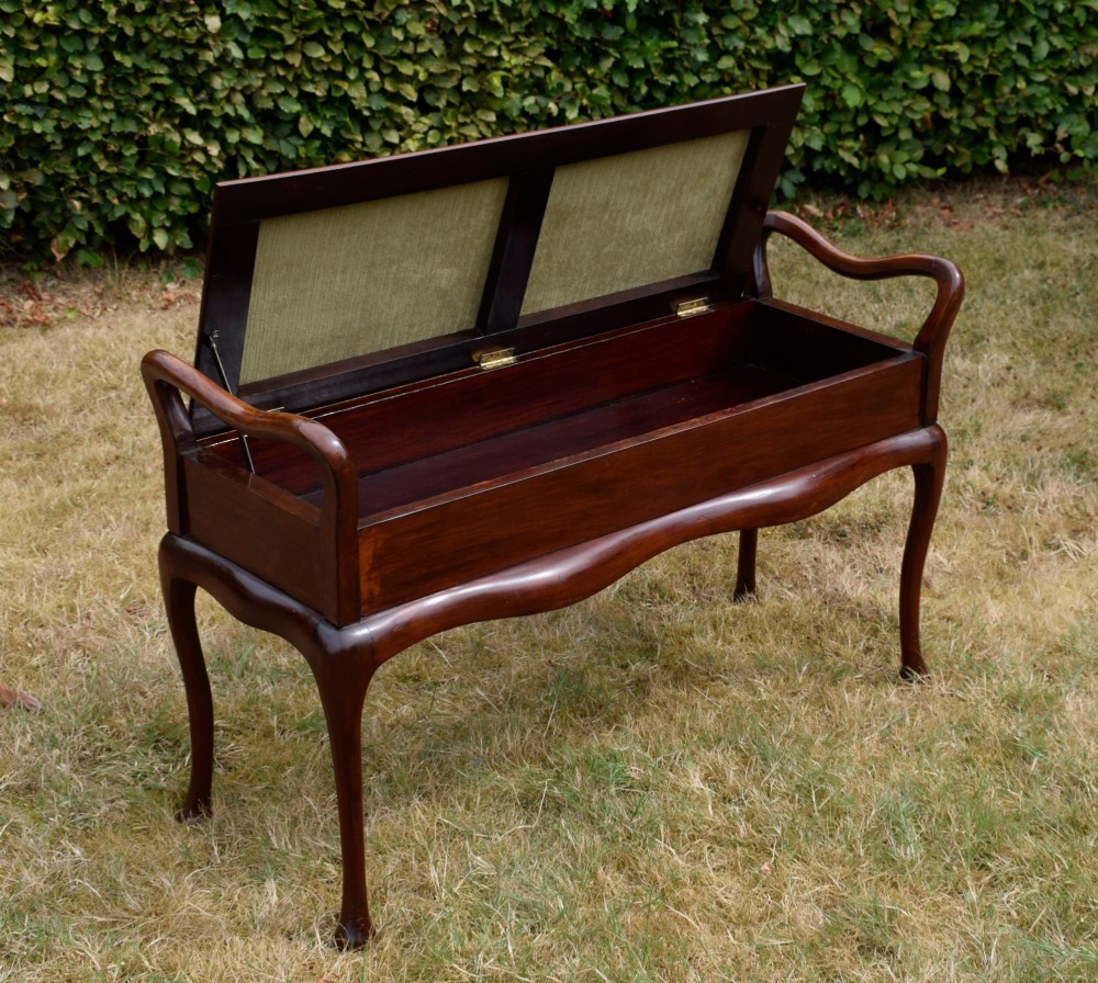 A mahogany duet piano stool with a blue patterned upholstered seat and carved cabriole legs. View XV