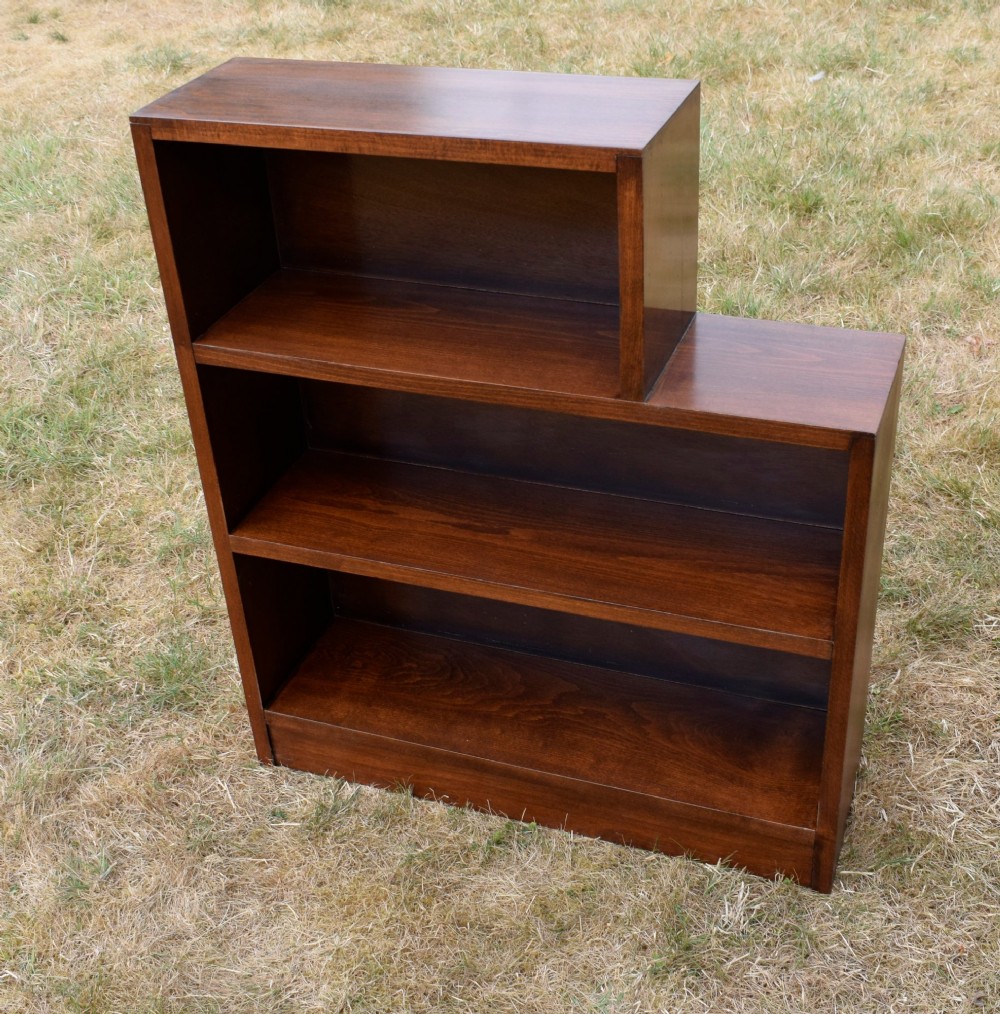 A dark brown wooden Art Deco bookcase featuring an asymmetrical stepped design with three open shelves. View VIII