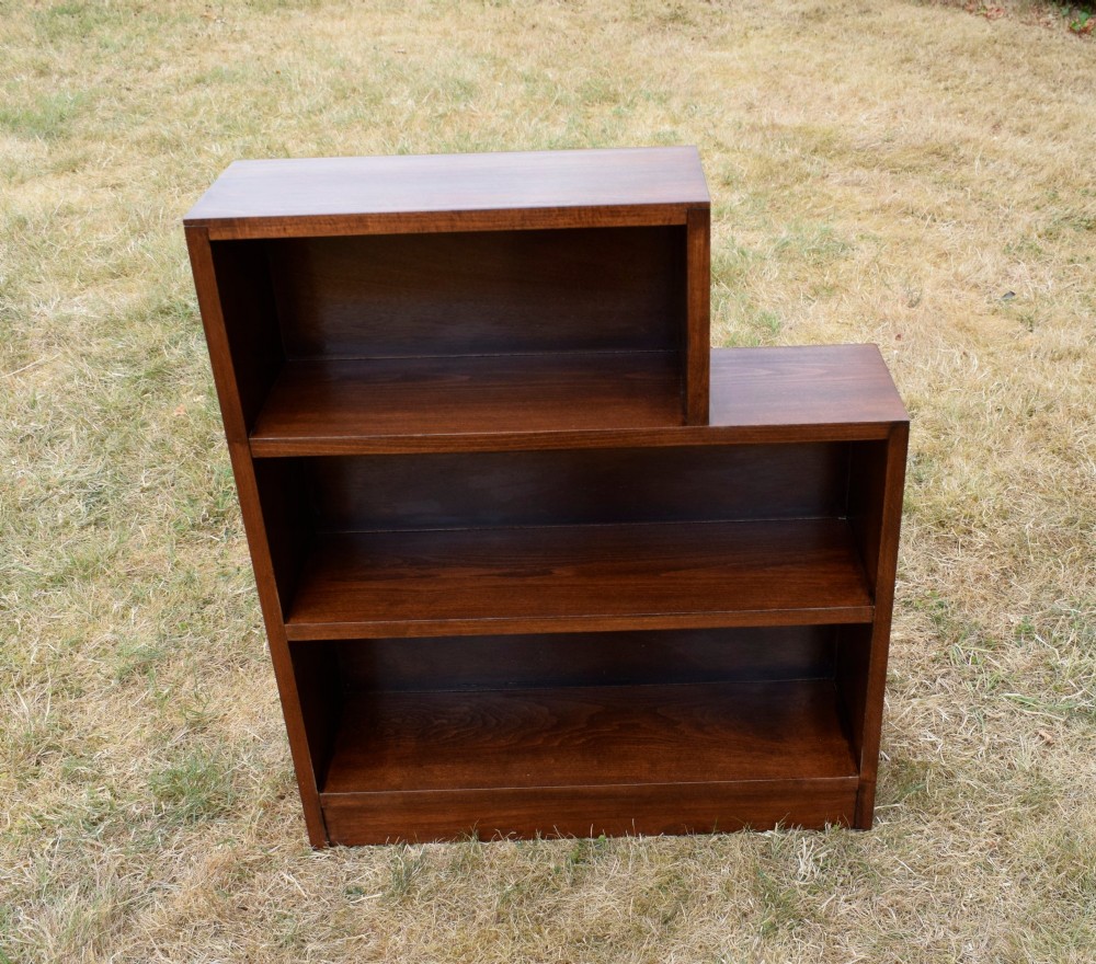 A dark brown wooden Art Deco bookcase featuring an asymmetrical stepped design with three open shelves. View X