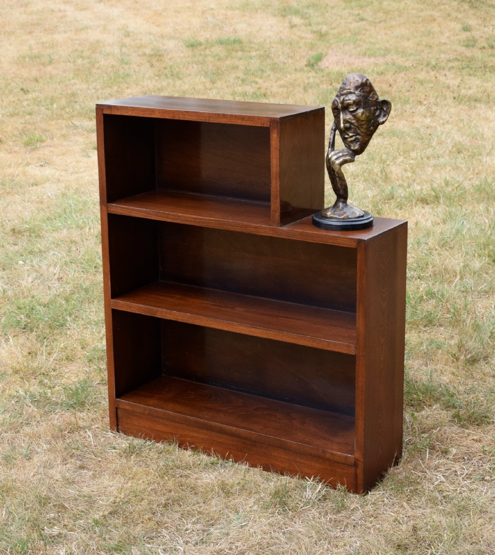 A dark brown wooden Art Deco bookcase featuring an asymmetrical stepped design with three open shelves. View XI