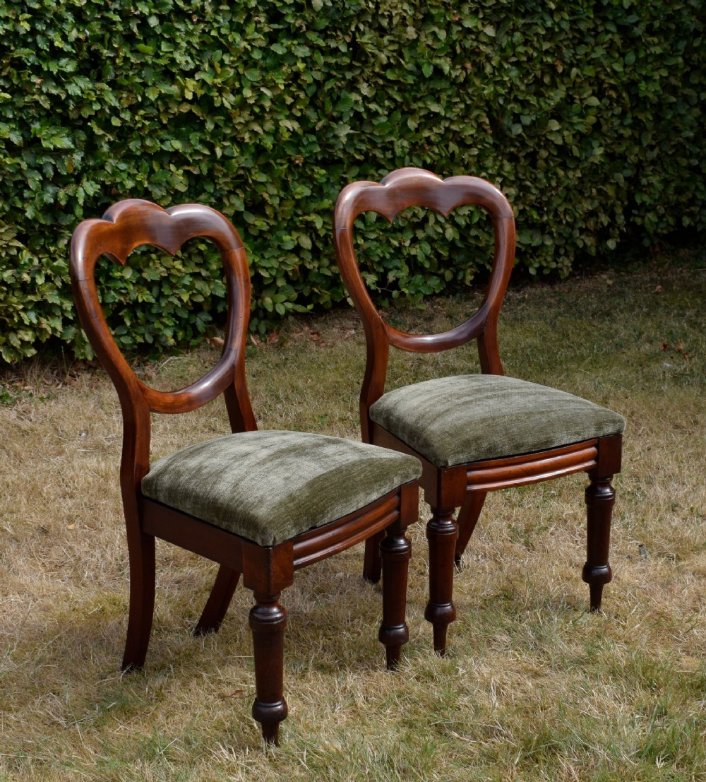 A pair of Victorian mahogany crown back dining chairs with green velvet upholstered seats and turned front legs. View II