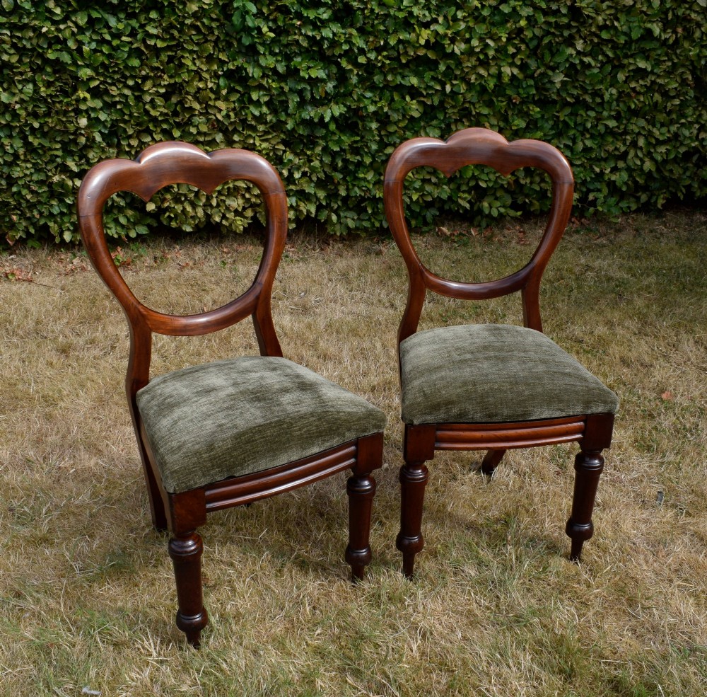 A pair of Victorian mahogany crown back dining chairs with green velvet upholstered seats and turned front legs. View IV
