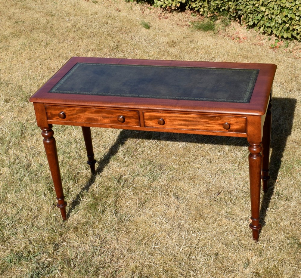 A Victorian mahogany writing desk featuring a green leather inset top with gold tooling, two frieze drawers with turned knob handles, and four slender turned legs. View III
