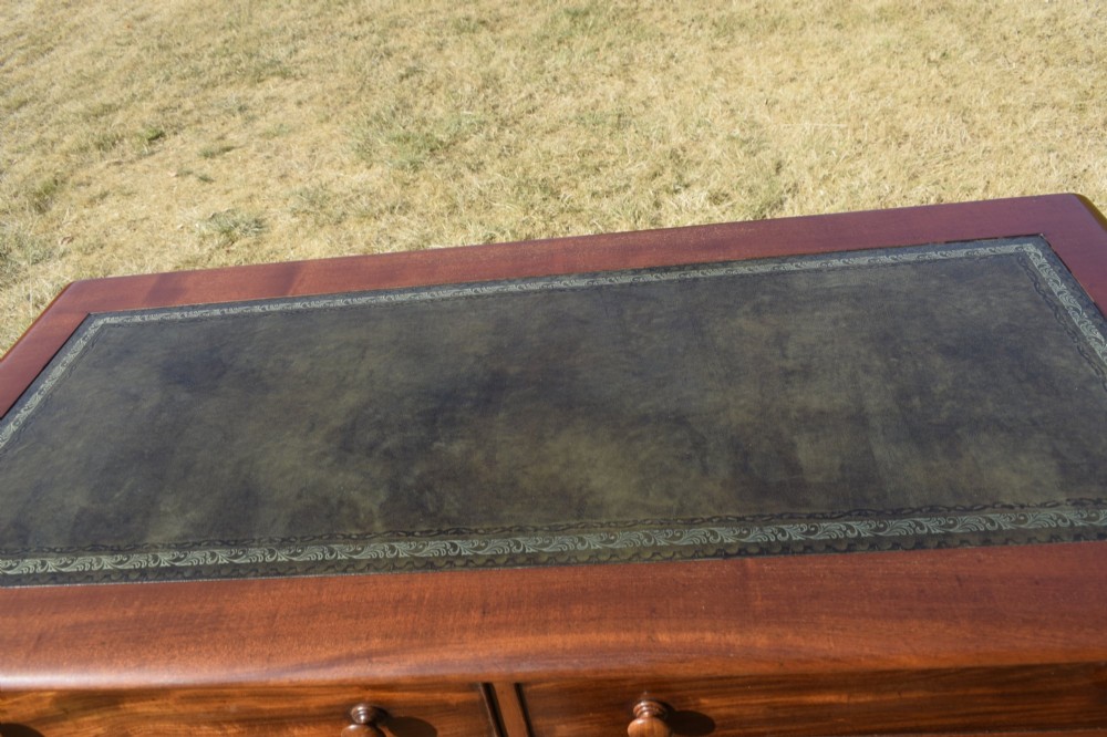 A Victorian mahogany writing desk featuring a green leather inset top with gold tooling, two frieze drawers with turned knob handles, and four slender turned legs. View VII