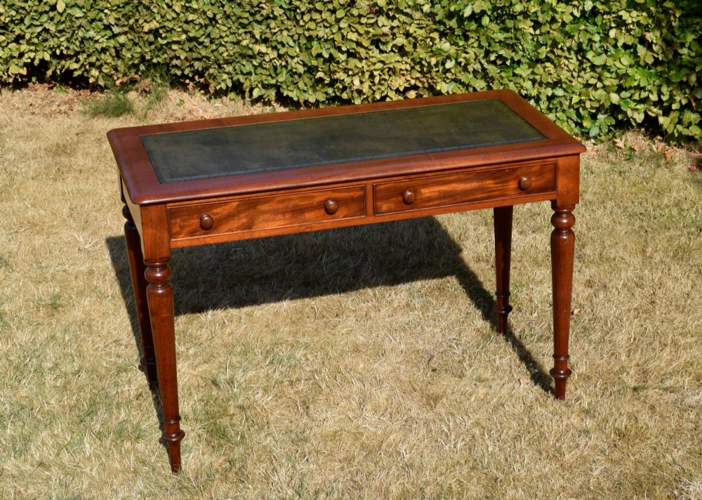 A Victorian mahogany writing desk featuring a green leather inset top with gold tooling, two frieze drawers with turned knob handles, and four slender turned legs. View XI