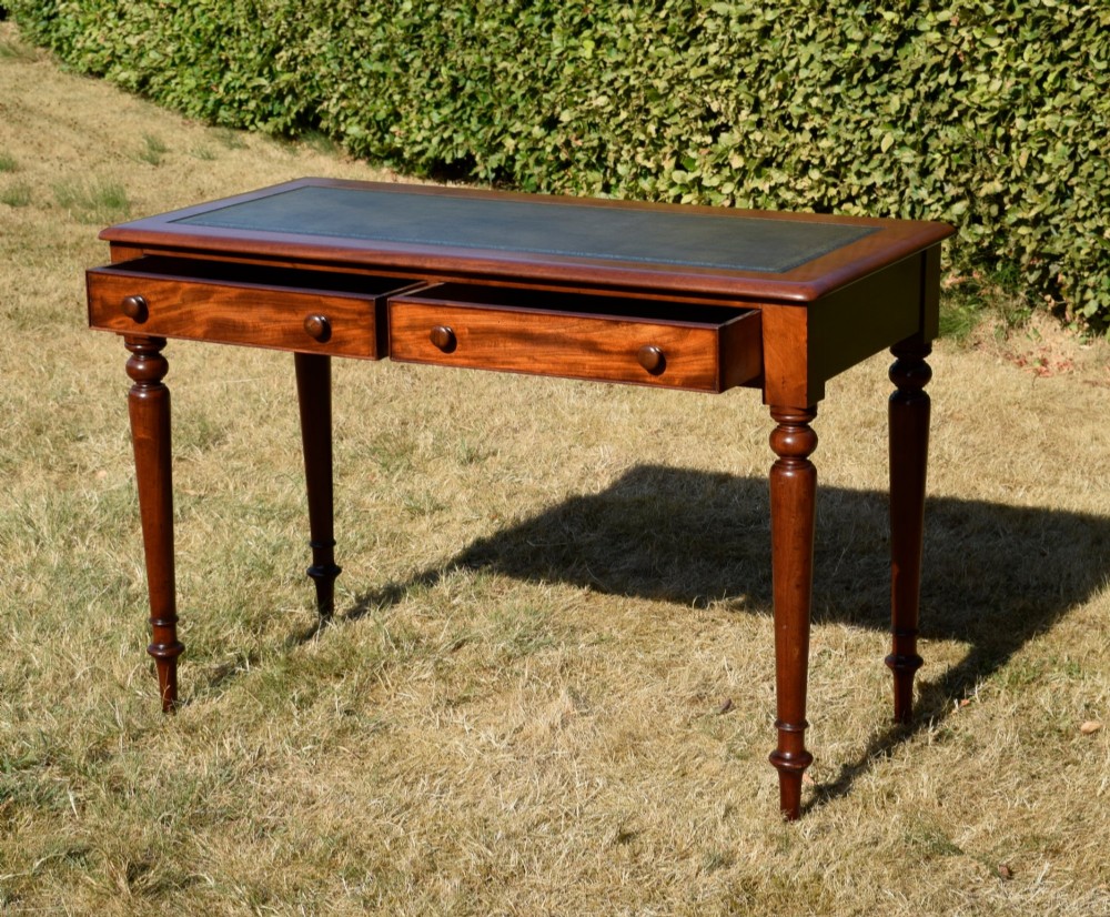 A Victorian mahogany writing desk featuring a green leather inset top with gold tooling, two frieze drawers with turned knob handles, and four slender turned legs. View XII