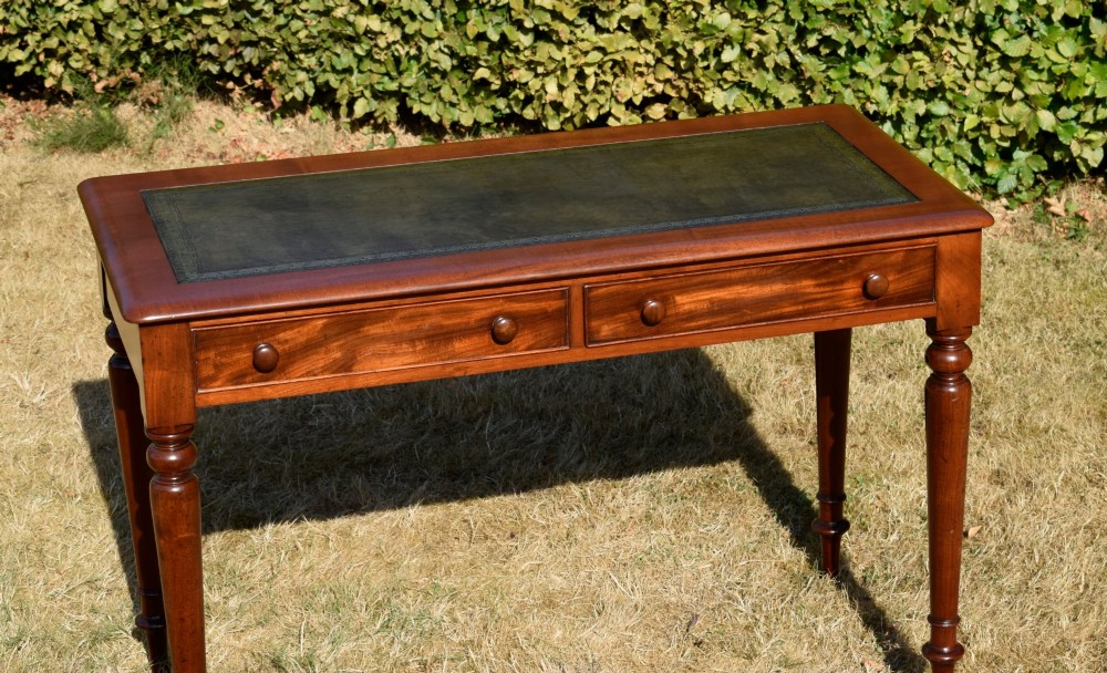 A Victorian mahogany writing desk featuring a green leather inset top with gold tooling, two frieze drawers with turned knob handles, and four slender turned legs. View XIII