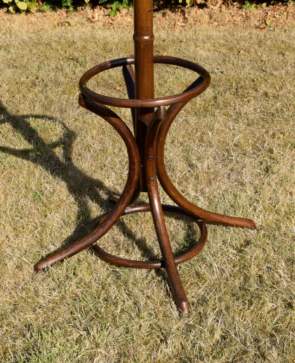 A dark brown bentwood coat and hat stand featuring curved upper hooks, a turned central post, an umbrella ring, and curved tripod legs. View XIV