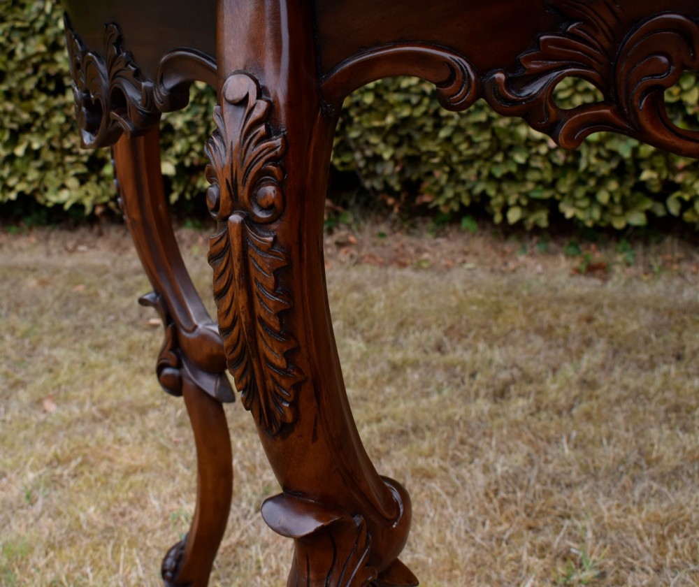 A dark mahogany demi-lune console table featuring deep acanthus leaf carvings on the frieze and three cabriole legs. View VIII